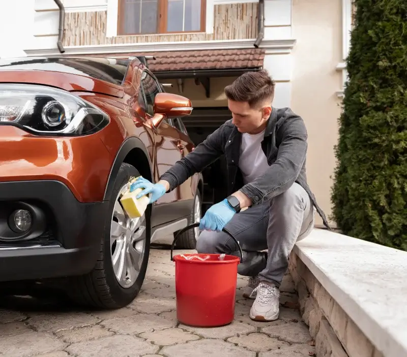 Lavage auto à domicile Saint-Georges-Montcocq : professionnel intervenant sur un véhicule